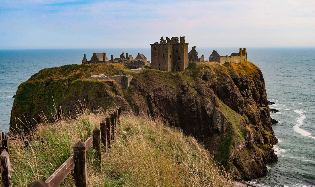 A dramatic view of a castle on the rugged coast of Scotland